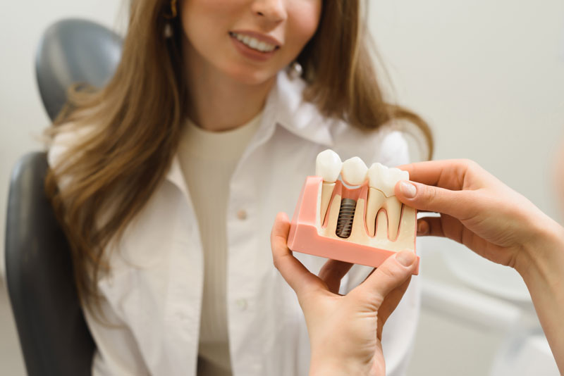 Dental Patient Getting Shown A Dental Implant Model During Her Consultation in Flower Mound, TX