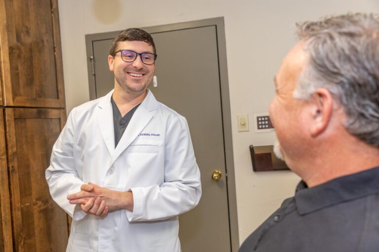 Dr. Vickers smiling at a wisdom tooth removal patient after he has told him how to avoid getting dry socket.