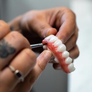 Lab Technician Painting All-In-One Solution Prosthetic Teeth