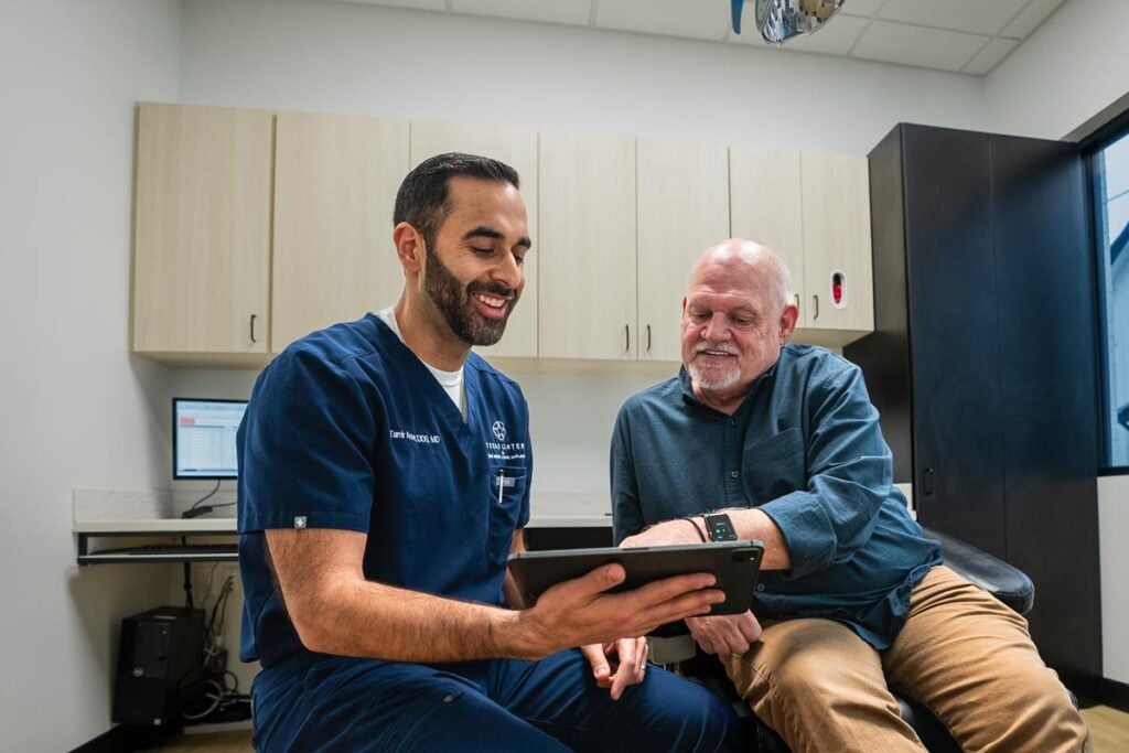 Wisdom Tooth Surgeon Dr Anver Showing Patient Treatment Plan On Tablet